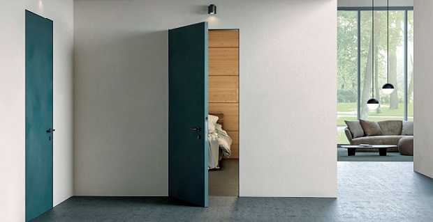 Porta filomuro a battente Filum di Dierre con rivestimento RAL a contrasto con la parete.